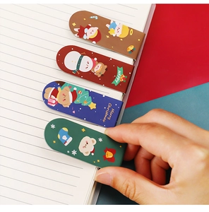 Detail of four colorful cartoon Christmas magnetic bookmarks on notebook paper