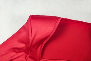 Detail shot of the neat stitching on a red satin dress neckline and shoulder seam