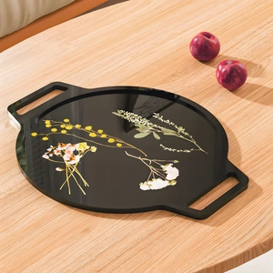 Close-up of a black glossy tray with handles and elegant floral patterns for decor