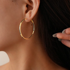 Gros plan détaillé de boucles d'oreilles géométriques plaquées or 14k avec émail noir