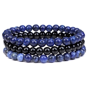 Close-up of three-piece natural blue and black beaded elastic bracelet set on white background