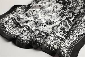 Close-up of black and white paisley silk scarf with elegant decorative patterns