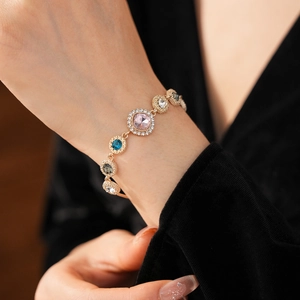 Detailed shot of gold-plated bracelet featuring vibrant multi-colored crystals on wrist