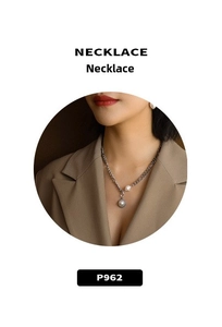 Close-up of a luxury silver chain necklace with a large round pearl and irregular pearl pendant