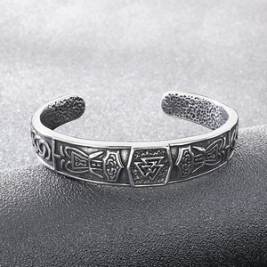 Detailed close-up of Viking wolf head bangle with Valknut engravings and runic patterns