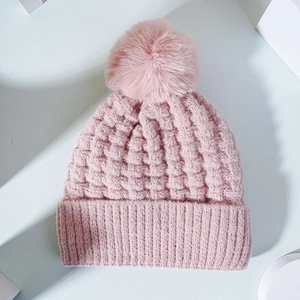Pink knit beanie with faux fur pom-pom and thick waffle texture for winter warmth