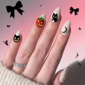 Detail of almond nails featuring Halloween pumpkin and black cat hand-painted art