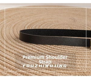 Detail of high-quality black leather shoulder strap with fine grain texture and slim design