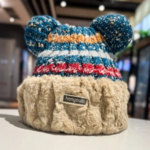 Close-up of colorful knit winter hat with faux fur trim and cute ear accents