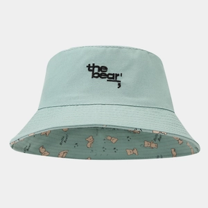 Close-up of mint green bucket hat featuring black 'the bear' embroidery and bear patterns