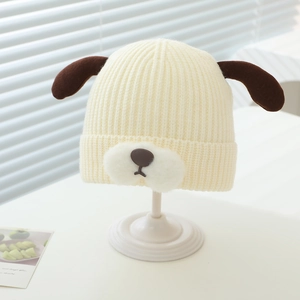 Detailed knit texture of cream baby winter hat with cute brown puppy ear accents