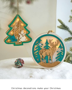 Detail of wooden glowing Christmas ornaments with deer and snowman on snow scene