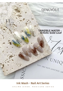 Artistic press-on nails featuring marble ink smoke effects and 3D gold relief textures