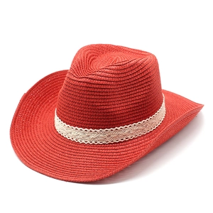 Close-up of deep red woven straw sun hat featuring elegant white lace ribbon detailing