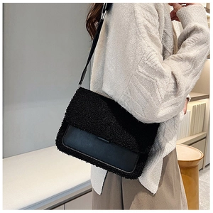 Detail of black lamb wool and leather patchwork crossbody bag shown on a model