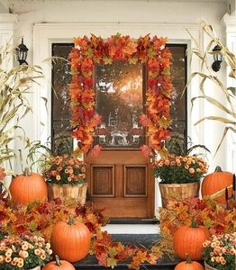 Detailed close-up of realistic fall maple leaf garland wrapped around a wooden door frame