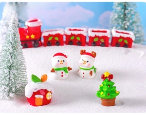 Miniature Christmas set with red train, snowman, Xmas tree and candy house on fake snow