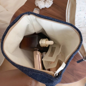 Retro denim canvas makeup bag with spacious interior shown from a top-down view