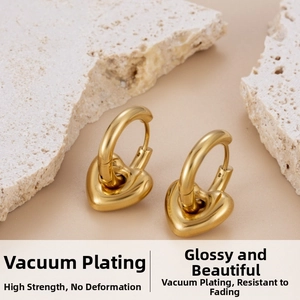 Detail of gold heart earrings on stone display featuring vacuum plating finish
