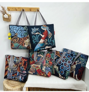 Artistic tote bags with folk prints and striped handles hanging on a rustic wooden wall
