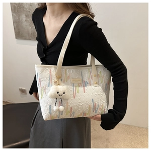 Detailed embroidery on white canvas tote bag with a cloud plush pendant charm