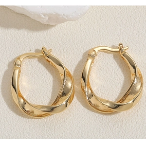 Luxury gold twisted hoop earrings with a sleek metallic finish in a minimalist design