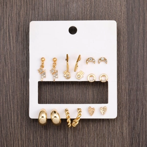 Golden earring set featuring moon, lightning and star motifs with rhinestones on a white card