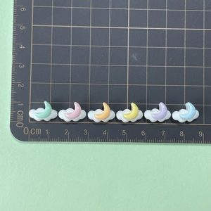 Miniature resin moon and clouds charms shown next to a ruler for 2.5cm scale detail