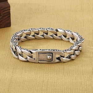 Detailed macro view of vintage silver stainless steel chain link bracelet with intricate patterns