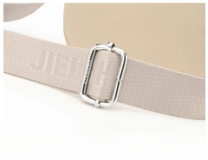 Detail of adjustable woven nylon strap and polished silver metal buckle on a shoulder bag