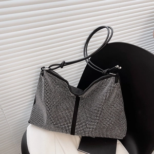 Sparkling black rhinestone tote bag with knotted shoulder straps on a black chair