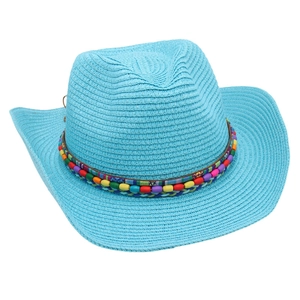 Detail of colorful beaded band on a blue woven straw cowboy hat with a bohemian style