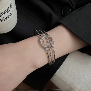 Detailed macro shot of layered silver metal twist bracelet with intricate textures