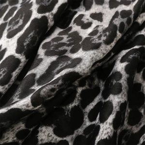 Macro shot of cotton linen scarf texture featuring a stylish grey and black leopard print