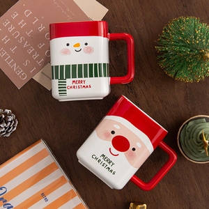 Ceramic Santa and Snowman Christmas mugs with Merry Christmas text on wooden table