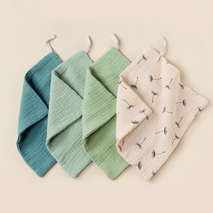 Close-up of 4-pack muslin baby washcloths with soft cotton texture and hanging loops