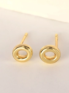 Macro shot of polished gold-plated circular hoop earrings with minimalist design