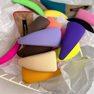 Close-up of colorful triangular sponge BB hair clips in a white metal basket