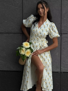 Detailed close-up of puff sleeves and yellow tulip print on a white cotton dress