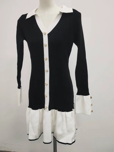 Close-up of knit dress featuring white ruffles, contrast collar, and pearl button details