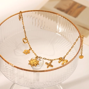 Gold plated stainless steel bracelet with heart, sun and butterfly charms on glass