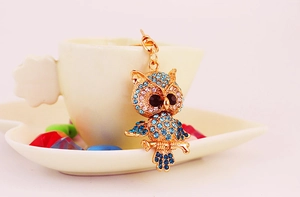Detailed close-up of crystal owl keychain with blue and pink rhinestones on gold metal