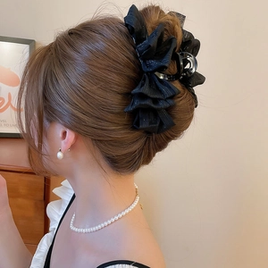 Detail view of a large black chiffon hair claw clip styled on a woman's hair