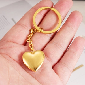 Golden heart-shaped locket keychain made of stainless steel held in hand for DIY photos