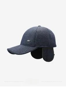 Detail of navy knit winter baseball cap featuring ear flaps and metal sport emblem