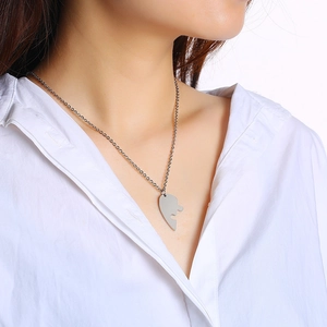 Close-up of silver stainless steel half-heart puzzle pendant necklace on model