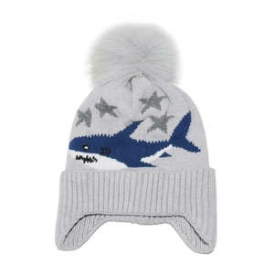 Detail view of winter kids knit hat featuring shark patterns and large faux fur pompom