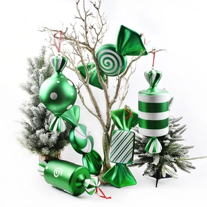 Green and white Christmas candy ornaments hanging on golden branches for festive decor
