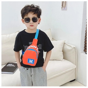 Gros plan sur un sac de poitrine orange pour enfant porté par un petit mannequin
