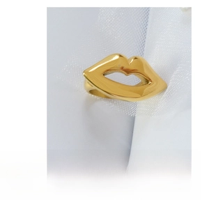 Detailed top view of a gold-plated titanium steel lip-shaped ring on a mesh fabric background